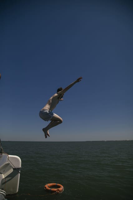 Lisbon: Catamaran Boat Party with Music, Open Bar & Dives - Cool-off time from a ladder: how the water access works